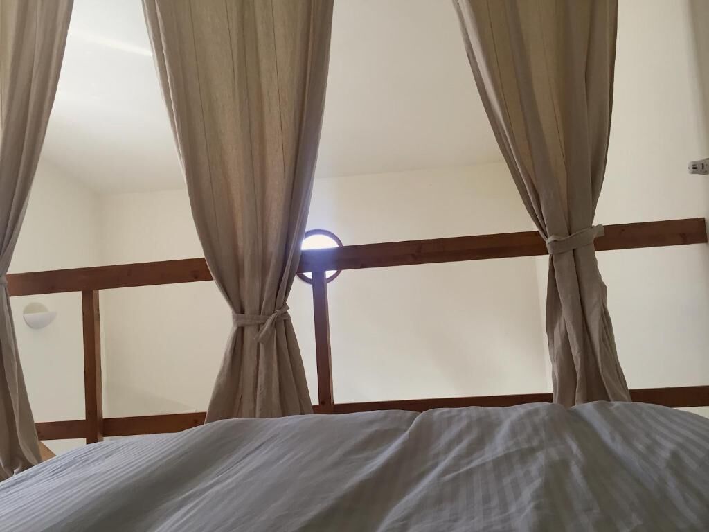 A bed with a white bedspread and a wooden headboard.