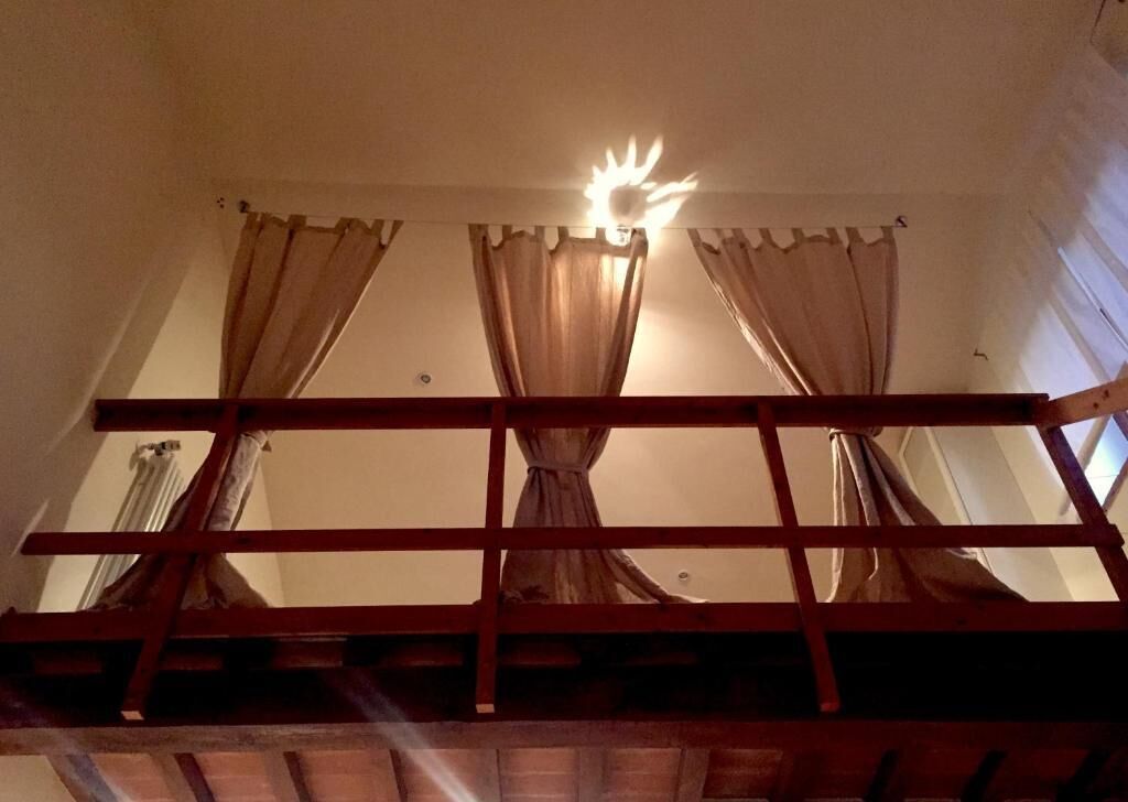 Ein Zimmer mit Etagenbett, Vorhängen und einer Deckenleuchte.