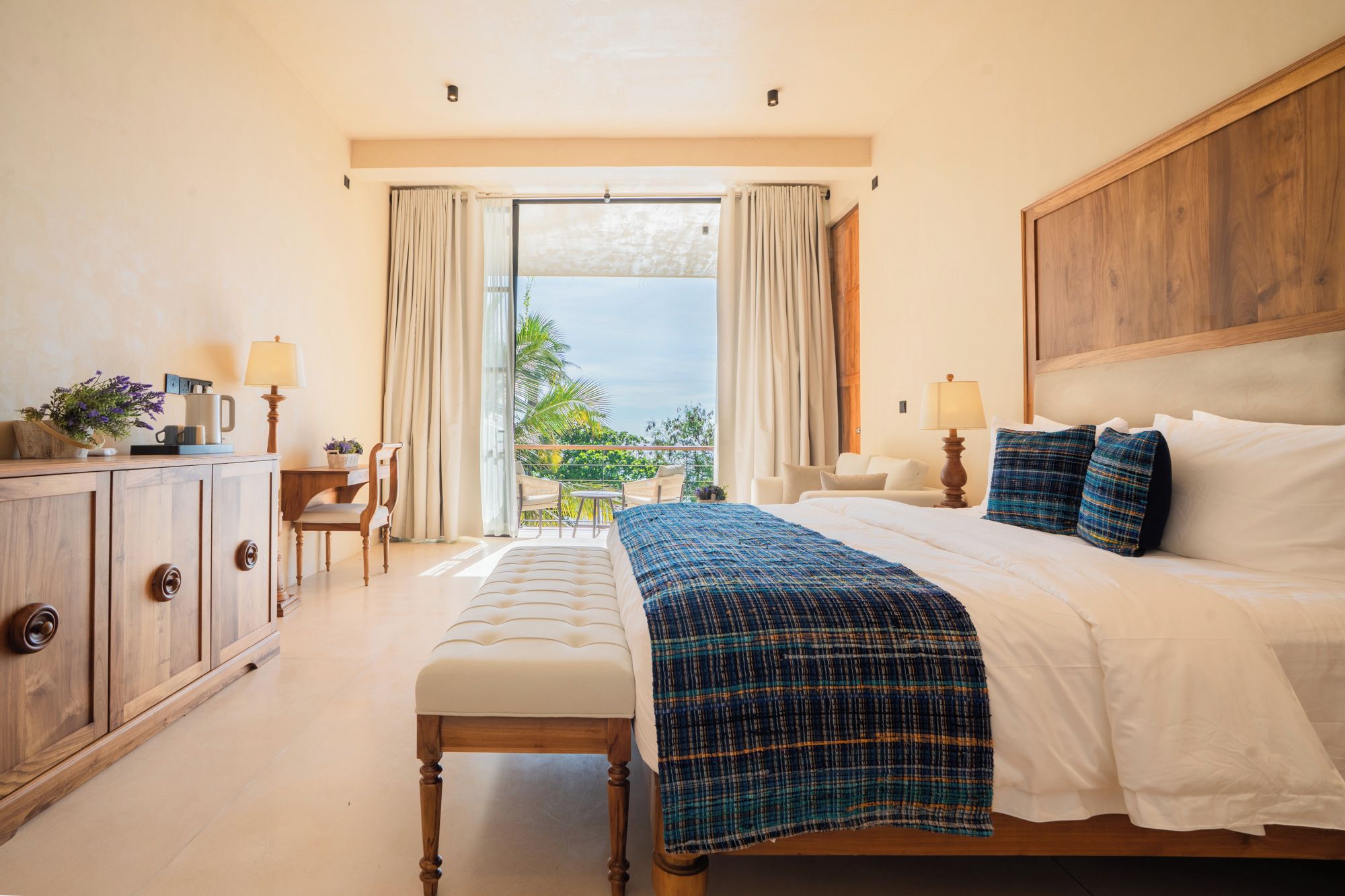 Habitación de hotel con cama, escritorio, silla y vistas al exterior.