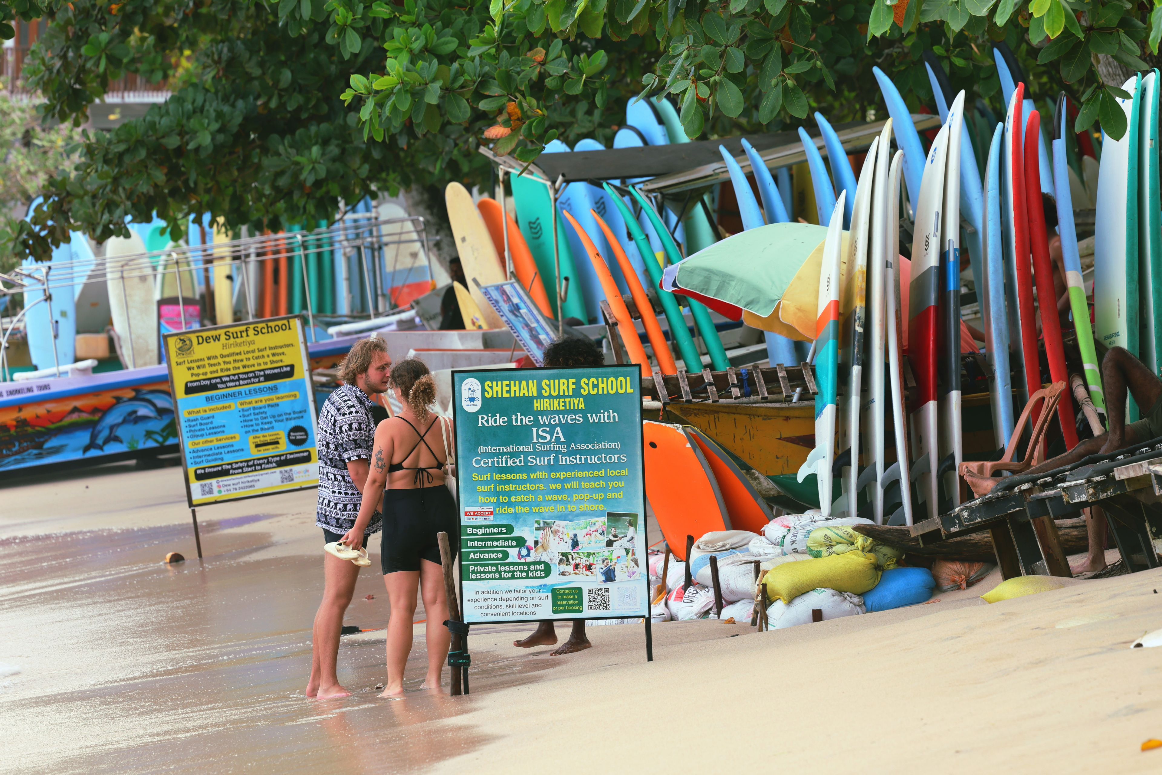 A beachside surf school with surfboards and instructional signs.