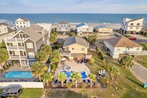 A coastal residential area with multiple houses, a swimming pool, and a view of the ocean. - Good Ol' Days: Private Pool, Hot Tub & Steps to the Beach (Murrells Inlet)