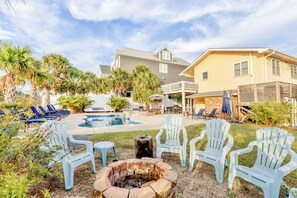 A backyard with a swimming pool, lounge chairs, and a fire pit. - Good Ol' Days: Private Pool, Hot Tub & Steps to the Beach (Murrells Inlet)