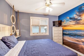 A bedroom with a bed, a ceiling fan, a window with blinds, a dresser, and a TV. - Good Ol' Days: Private Pool, Hot Tub & Steps to the Beach (Murrells Inlet)