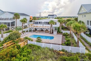 A residential area with a swimming pool, multiple houses, and a white picket fence. - Panacea: Oceanfront Charm with Pool, & Private Beach Walkway (Murrells Inlet)