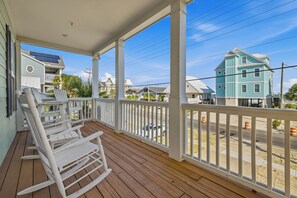A wooden porch with white railings and white rocking chairs. - Peachy Keen: Private Pool, Ocean Views & Steps from the Sand (Murrells Inlet)