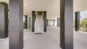 A covered walkway with a central staircase, flanked by columns, leading to a building entrance. - Peachy Keen: Private Pool, Ocean Views & Steps from the Sand (Murrells Inlet)