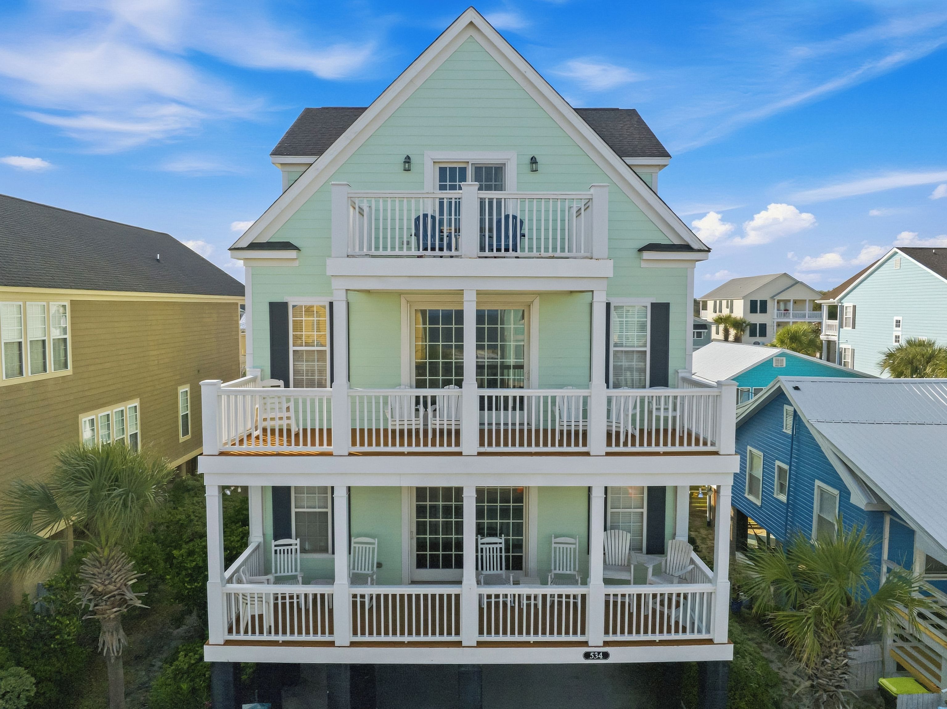 A two-story building with a balcony on the upper floor and a covered porch on the lower floor.