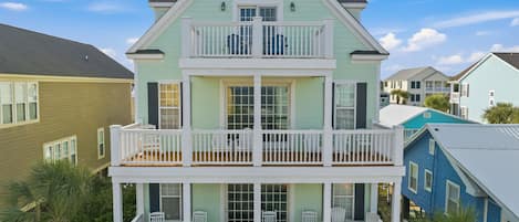 A two-story building with a balcony on the upper floor and a covered porch on the lower floor.