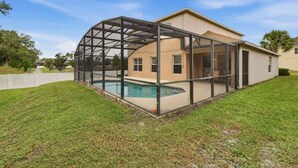 Una casa con una zona esterna coperta e una piscina.