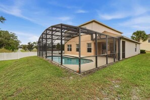 A house with a covered outdoor area and a swimming pool. - 5BR Private Pool Retreat  Near Disney (Kissimmee)