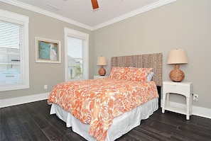 A bedroom with a bed, two nightstands, a headboard, and two lamps.