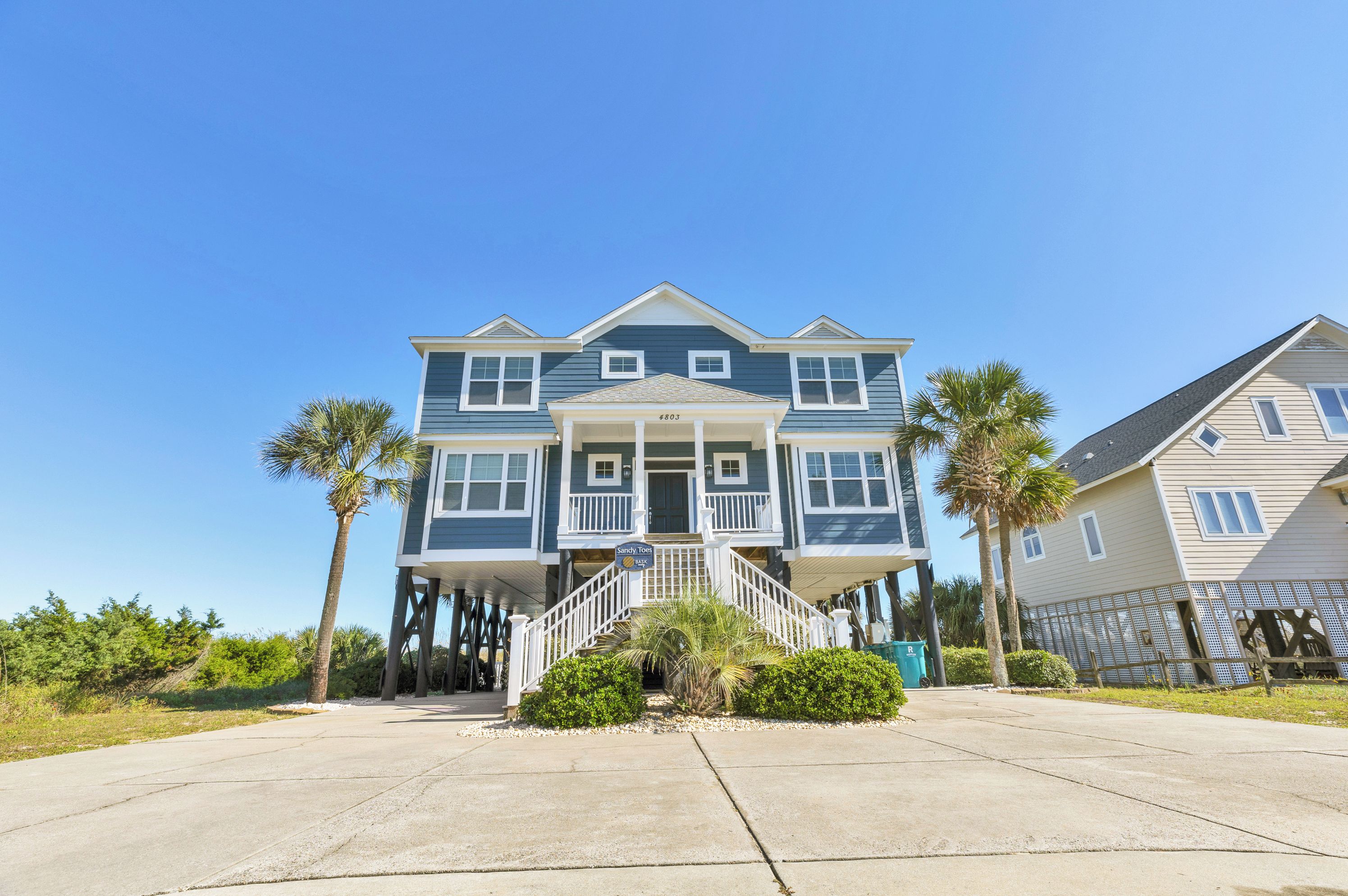 A two-story house with a covered front porch and a staircase leading to the entrance.