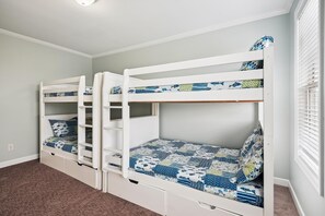 A room with bunk beds, each with a lower shelf and drawers. - Sun-S-Up: Private Pool, Steps to the Beach & Surfside Pier (Surfside Beach)