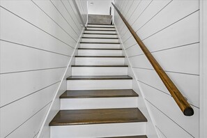 A staircase with white walls and wooden steps.