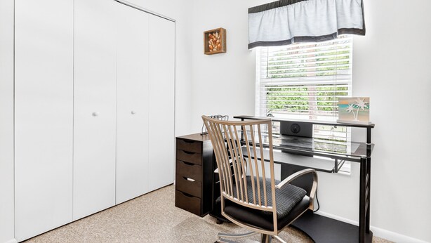 Un dormitorio con cama, escritorio y armario.