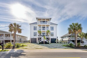 A two-story building with a central entrance, a covered porch, and a driveway leading to a parking area. - Best Of Both Worlds: Views, Pool, Location & Luxury (Murrells Inlet)