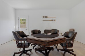 Een vergaderruimte met een ronde tafel, vier stoelen en twee paddles aan de muur.