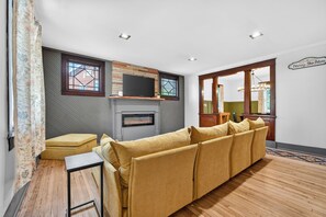 A living room with a sofa, a television, and a fireplace.