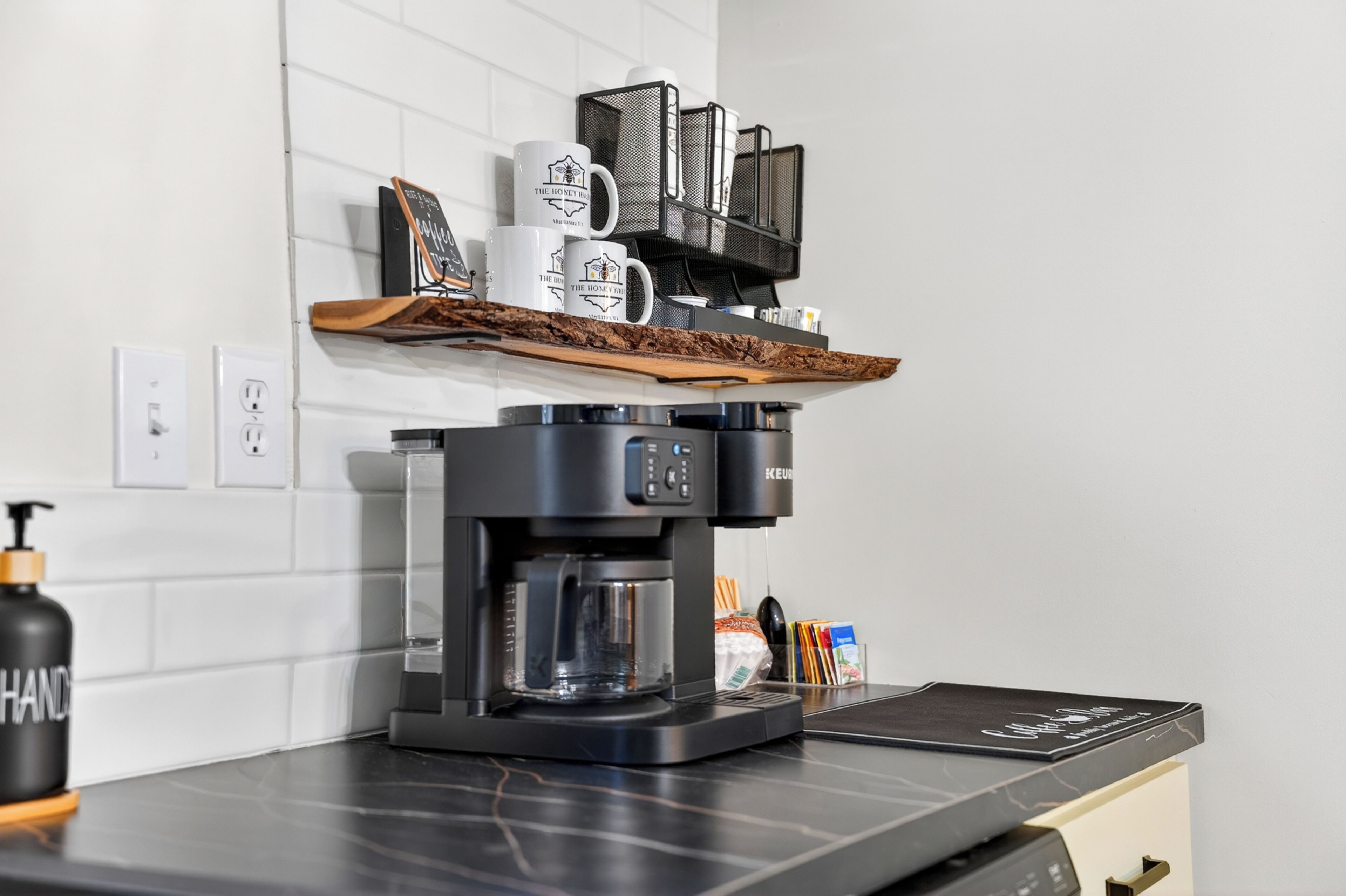 Een koffieapparaat op een keukentafel met een koffiemolen, een koffiezetapparaat en een koffiekan.