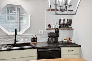 Eine moderne Küche mit integriertem Geschirrspüler, einer Kaffeemaschine und einem Fenster mit Blick.