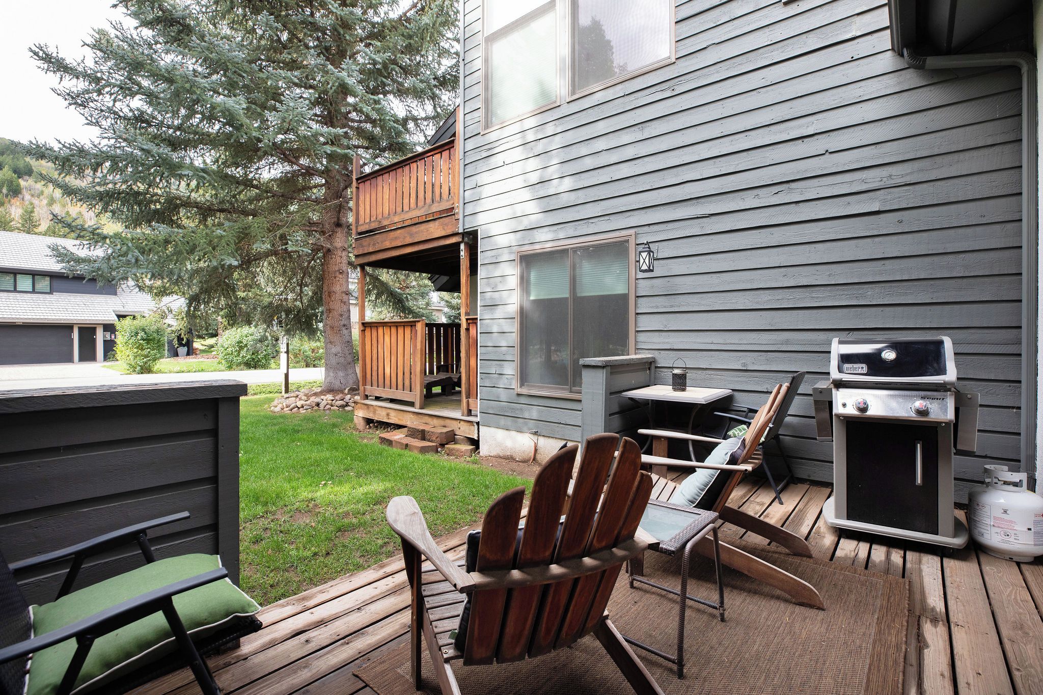 A deck with outdoor furniture, a grill, and a small table.