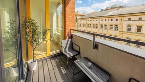 Ein Balkon mit Holzboden, einem Blumentopf, einem Stuhl und einem Tisch.