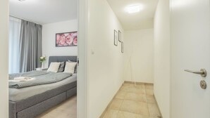 Ein Schlafzimmer mit einem Bett, einem Nachttisch und einem Fenster mit Vorhängen.
