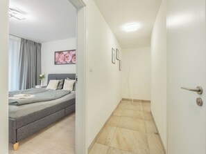 Ein Schlafzimmer mit einem Bett, einem Nachttisch und einem Fenster mit Vorhängen.