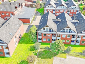 Um bairro residencial com várias casas de dois andares, cada uma com telhado inclinado e varanda.