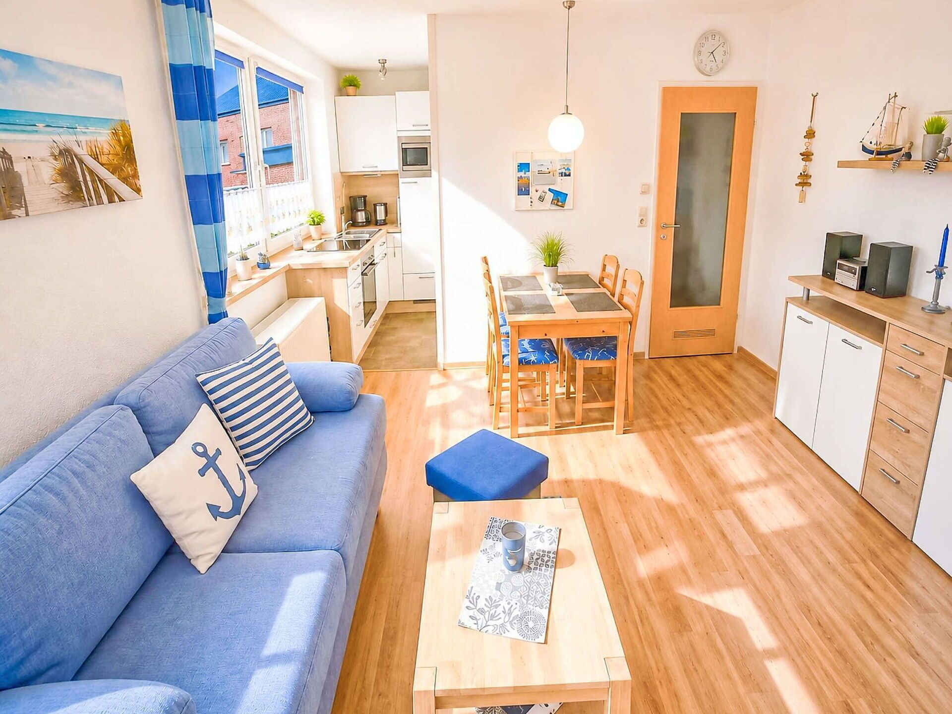 Een compacte woonruimte met een bank, een eettafel en een kitchenette.