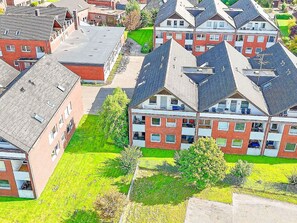 Ein Wohngebiet mit mehreren zweistöckigen Häusern, jedes mit geneigtem Dach und einem Balkon.