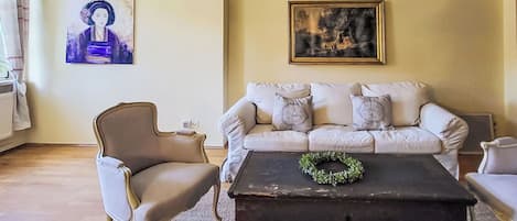 A living room with a sofa, armchair, and a coffee table with a wreath.