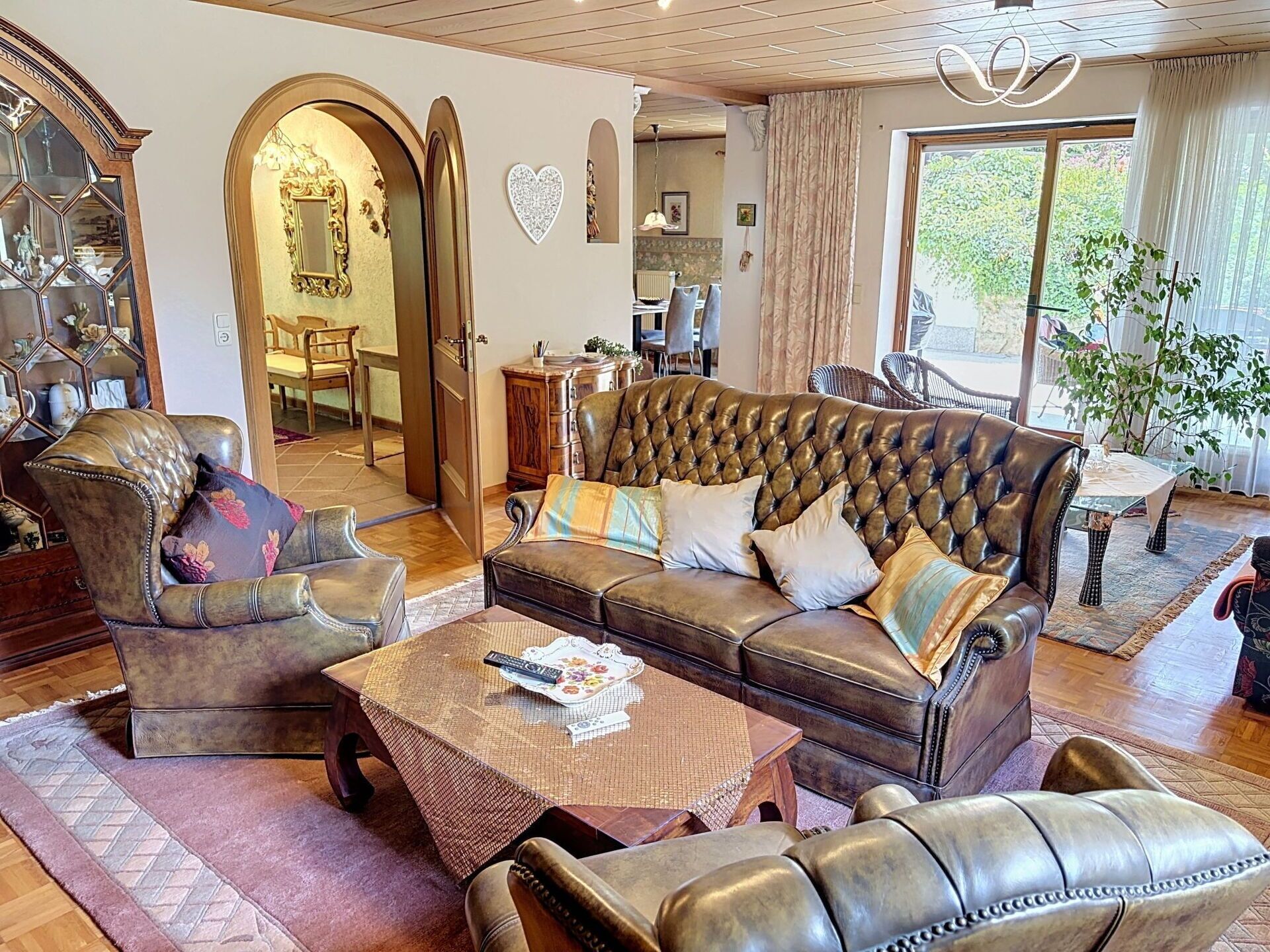 Un salon spacieux avec un canapé en cuir, des fauteuils et une table basse.