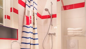 Un baño con ducha, lavabo, inodoro y toallero.