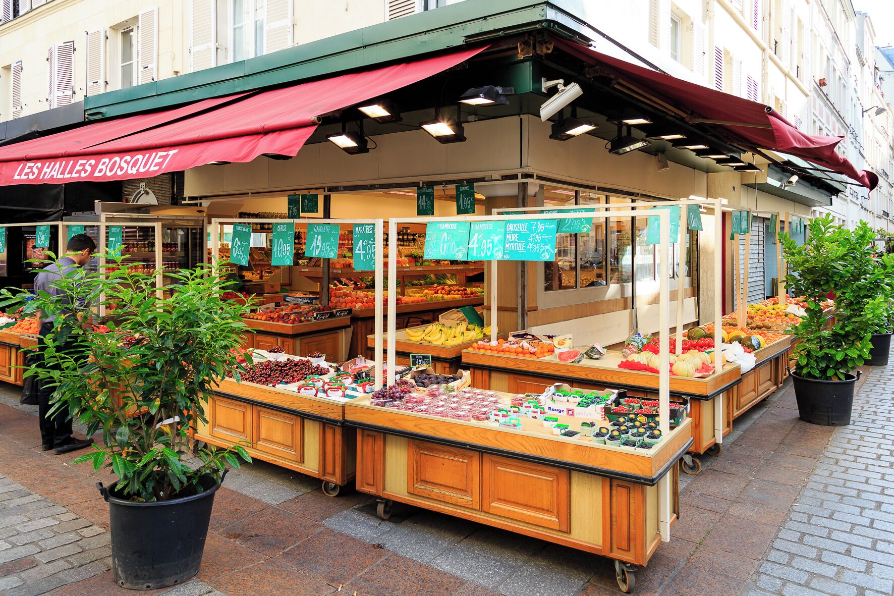 Een markt in de open lucht met verschillende kraampjes die fruit, groenten en andere waren verkopen.
