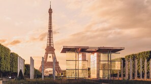 La Tour Eiffel, avec une structure moderne en verre en premier plan.