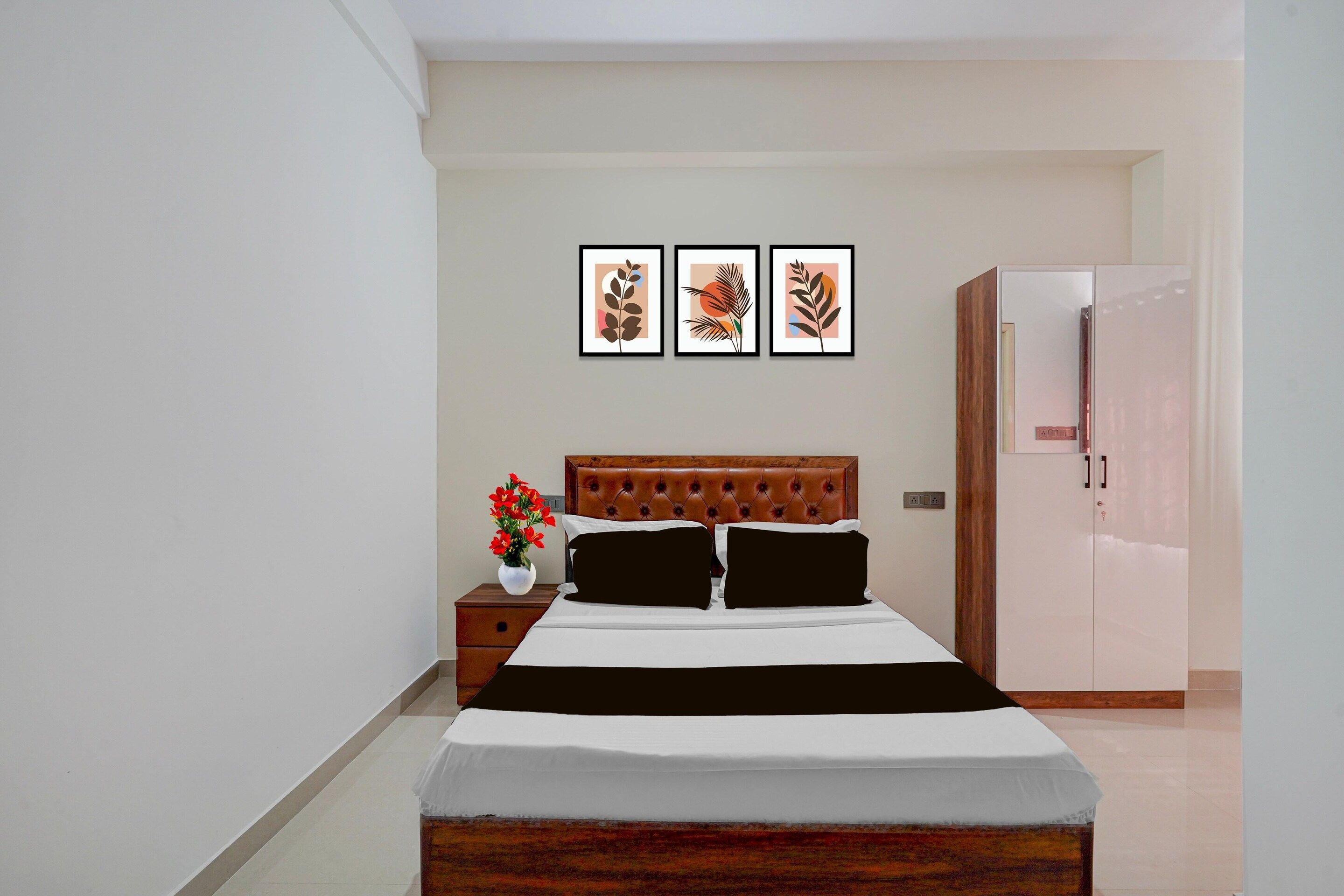 A bedroom with a bed, a nightstand, a dresser, and three framed pictures on the wall.