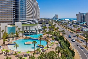 Ein Hotel mit großem Pool, Palmen und Blick auf den Strand.