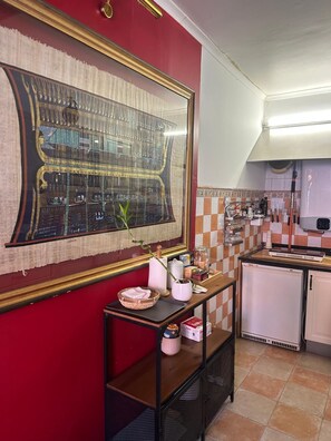 Eine Küche mit roter Wand, einem großen Spiegel und einer gefliesten Spritzschutzwand.