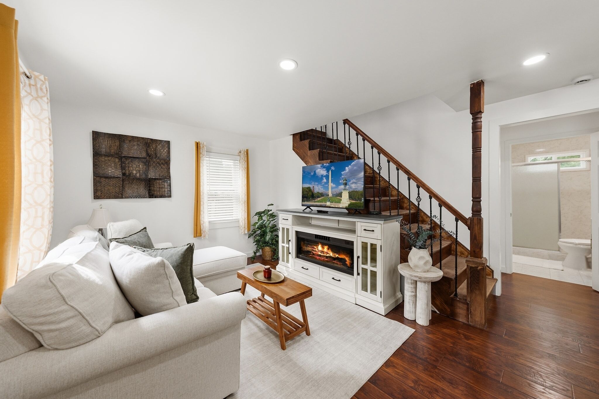 A living room with a fireplace, a sofa, a coffee table, and a television.