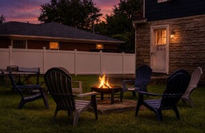 An outdoor seating area with Adirondack chairs and a fire pit. - New & Cozy 3BR Retreat | Sleeps 6 | Free Parking ! (Alexandria)