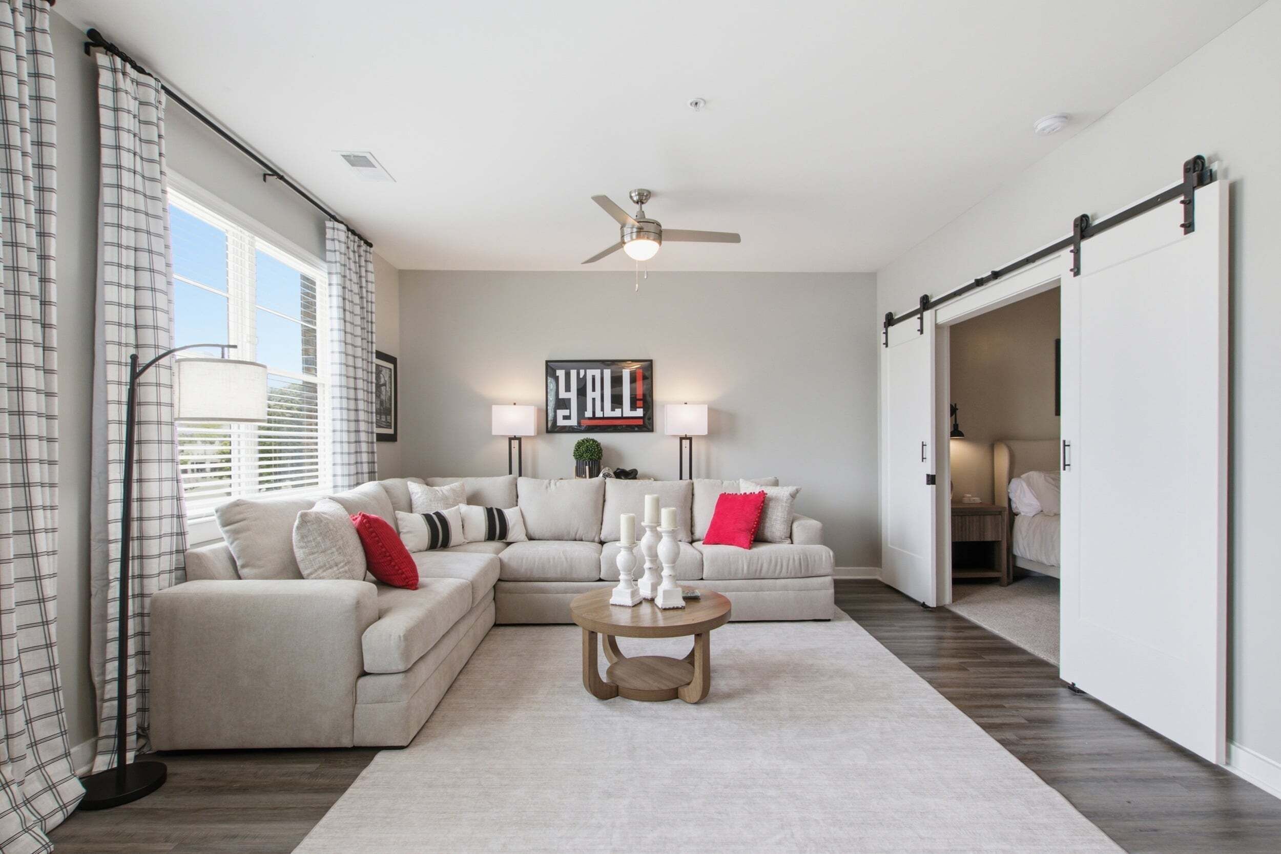 A modern living room with a sectional sofa, a coffee table, and a ceiling fan.