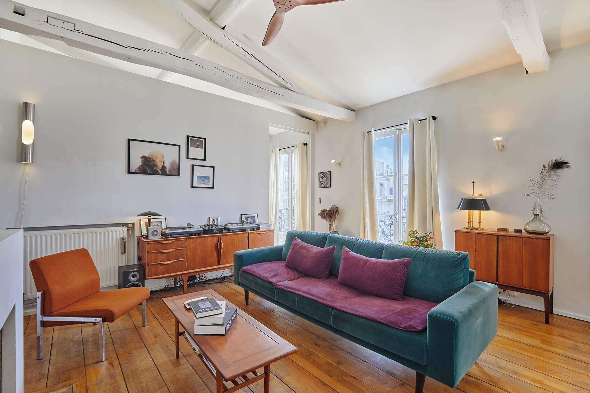 Un salon comprenant un canapé, une table basse, un fauteuil et un meuble contenant une radio.