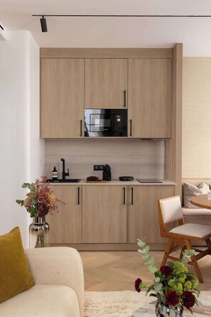 Une cuisine moderne avec des meubles en bois, un four à micro-ondes encastré et une machine à café.