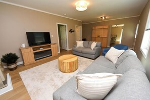 A living room with a television, sofa, and coffee table. - Peaks & Paws -Pet friendly, single level, sleeps 8 close to beach (Conway)