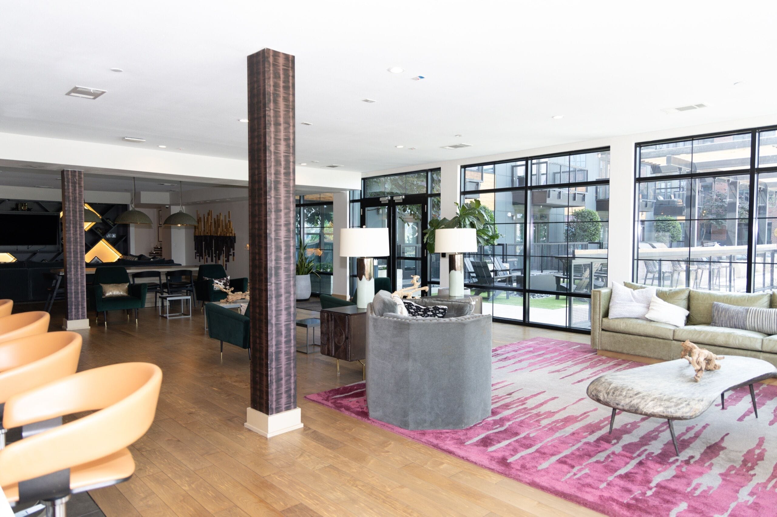 A spacious living area with a large window, a high ceiling, and a modern interior design.