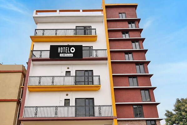 A multi-story hotel building with balconies and a sign indicating it is serviced by OYO. - Hotel Infocity Square Bhubaneswar (Bhubaneshwar)
