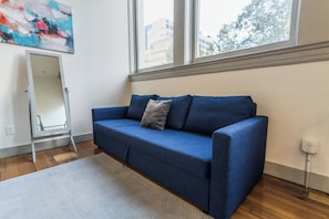 A room with a blue sofa, a white floor lamp, and a large window. - Urban Loft Escape - Nearby Parking Downtown - 2F (Louisville)