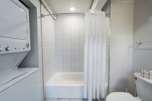 A bathroom with a shower, toilet, and a washing machine. - Urban Loft Escape - Nearby Parking Downtown - 2F (Louisville)