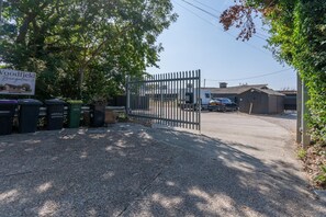 Een hek afsluit de oprijlaan naar een pand, met een bord waarop 'Woodfield Bungalow' staat.